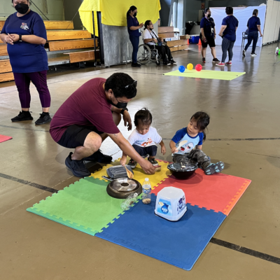 July 1, 2022: Dad and children make music at the Guam EHDI “Baby Jam” station at the Village Play Time held at the Yigo Gym.